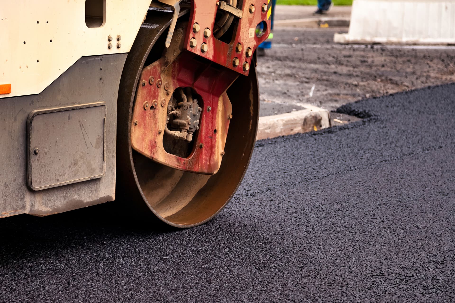 Asphalt sealcoating machine applying fresh sealant to a driveway